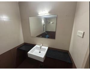 a bathroom with a white sink and a mirror at Hotel shree darshan Dwarka in Dwarka