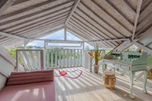 um quarto com um piano num deque de madeira em BoHo Bingin Beach Bali em Uluwatu