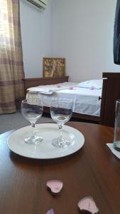 two wine glasses on a plate on a table at Барселона in Odesa