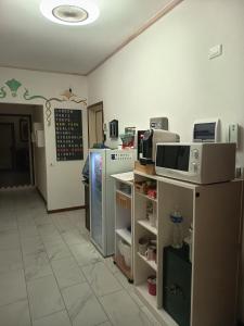 a kitchen with a refrigerator and a microwave at VillaGioveRooms in Prato