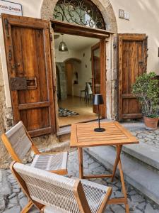 a wooden table and chairs on a patio at ALLOGGIO CASA IN PIETRA in Santu Lussurgiu +14 photos