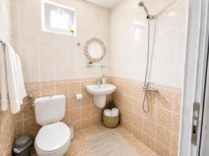 a bathroom with a toilet and a sink and a shower at Къща за гости Беглик Таш 2 in Primorsko