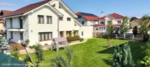 a house with a yard with a green lawn at Bungalow Ildy House in Sînmartin