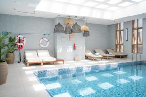 a swimming pool with lounge chairs and a swimming pool at Mercure Hotel Khamis Mushait by Accor in Khamis Mushayt