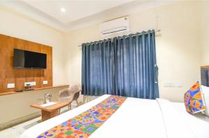 a hotel room with a bed and a tv at The Golden Plaza in Tarapith