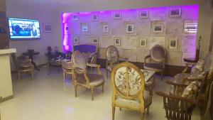 a room with chairs and a wall with purple lights at hotel le noble in Beirut +5 photos