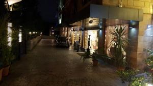 an empty street at night with a car parked outside at hotel le noble in Beirut