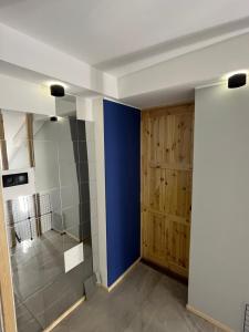 a bathroom with a blue wall and a shower at Agro Bieszczady 2 in Czarna