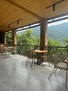 a patio with tables and chairs and a view of the mountains at Dilijan Tun Boutique Hotel in Dilijan