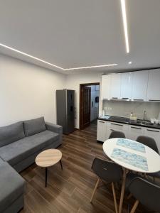 a living room with a couch and a table and a kitchen at Velipoja Guest House 1 in Velipojë