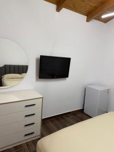 a bedroom with a mirror and a tv on the wall at Velipoja Guest House 1 in Velipojë