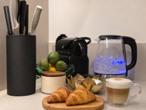 a table with a cup of coffee and croissants at Veleslaveenka - Spacious Apartment in Pilsen Old Town in Pilsen