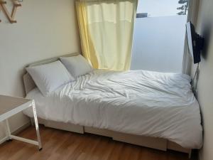 a small bed in a room with a window at Goseong Sustay Pension in Goseong