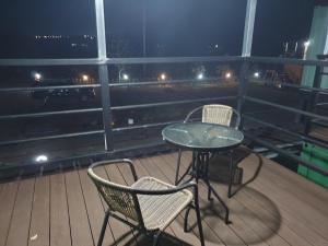 a table and two chairs on a balcony at night at Goseong Sustay Pension in Goseong +13 photos