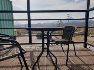 a table and two chairs on a porch with a view at Goseong Sustay Pension in Goseong