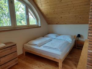 a bed in a small room with two windows at Świerkowy Las in Sanok