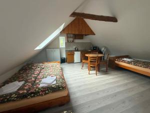 a room with two beds and a table and a kitchen at Statek u Potoka in Vimperk