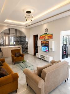 a living room with two couches and a tv at Résidence Les Bernier in Nianing