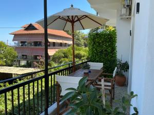 a balcony with a table and an umbrella at Niki Seaside Apartments in Platamonas