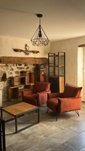 a living room with red chairs and a table at L'EMPREINTE in Salavas