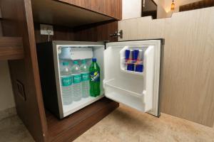 an open refrigerator with bottles of water in it at Estrella The Resort in Karjat