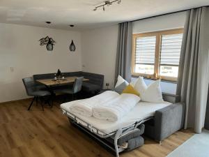 a bedroom with a bed with white pillows and a table at MAVI Apartment in Schlitters