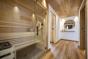 a glass shower in a bathroom with wooden ceilings at Dosplain Panoramic Apartments in Santa Cristina Gherdëina +96 photos