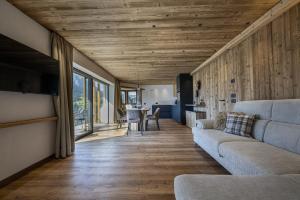 a living room with a couch and a table at Dosplain Panoramic Apartments in Santa Cristina Gherdëina