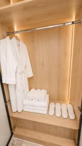 a closet with white towels on a wooden shelf at NestOne Apartment 39th floor in Tashkent +34 photos