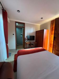 a hotel room with a bed and a television at Armatyr Motel in Kampala