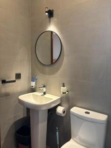 a bathroom with a sink and a toilet and a mirror at Armatyr Motel in Kampala