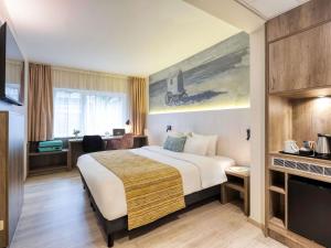 a hotel room with a bed and a tv at Mercure Oostende in Ostend +79 photos