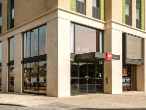 a building with large glass windows on a street at ibis Cambridge Central Station in Cambridge