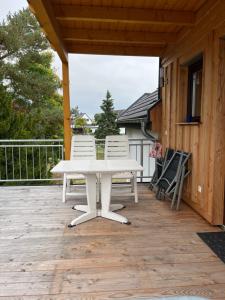 a white picnic table and chairs on a deck at Auszeit im Hunsrück in Braunshorn