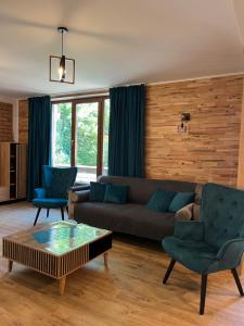 a living room with a couch and two chairs at Casa Carolianne in Bran