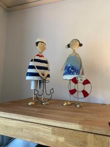 two wooden figurines on top of a wooden table at Ferienwohnung Austernfischer Ockholm in Ockholm