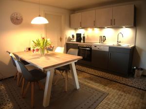 a kitchen with a wooden table with chairs and a sink at Ferienwohnung Austernfischer Ockholm in Ockholm