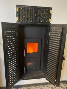 a black woodburning stove with an orange at Ferienwohnung Austernfischer Ockholm in Ockholm +11 photos