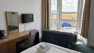 a hotel room with a bed and a desk and a mirror at The Sandpiper in Barmouth