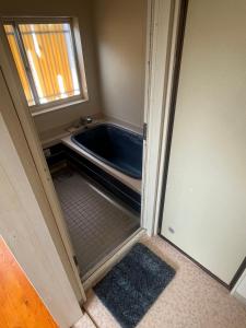 a bathroom with a bath tub in a room at 海岸道路沿い 磯の宿 in Minamiboso
