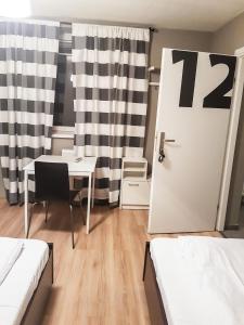 a room with a table and a door with the number at KWATERY KALINA-DUSZKA HOSTEL in Płock