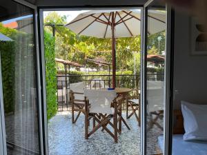 a table and chairs with an umbrella on a patio at Niki Seaside Apartments in Platamonas