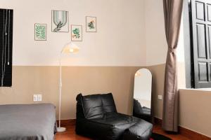 a bedroom with a black leather chair and a mirror at LaBo Homestay in Quan Lạn