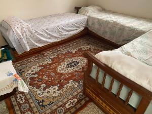 a bedroom with two twin beds and a rug at Moroccan Place in Larache
