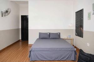 a bedroom with a bed with blue pillows at LaBo Homestay in Quan Lạn