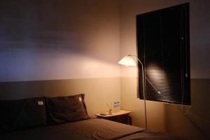 a bedroom with a bed and a lamp and a window at LaBo Homestay in Quan Lạn +2 photos