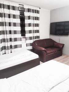 ein Wohnzimmer mit einem Sofa und einem TV in der Unterkunft KWATERY KALINA-DUSZKA HOSTEL in Płock