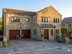 a brick house with a garage and a bike parked in front at The Peak View - Holmfirth in Cartworth