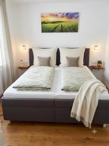 a bed in a bedroom with a picture on the wall at Wohnen im Grünen - Landidylle mit Komfort Nähe Linz in Pregarten