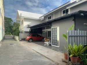 a red car parked in front of a building at Pion Hotel Ayutthaya in Phra Nakhon Si Ayutthaya